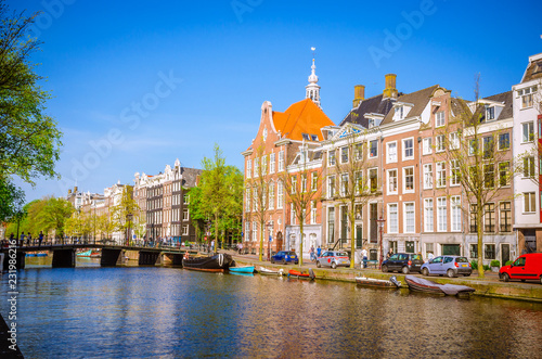 Traditional old buildings and and boats in Amsterdam, Netherlands. Canals of Amsterdam.