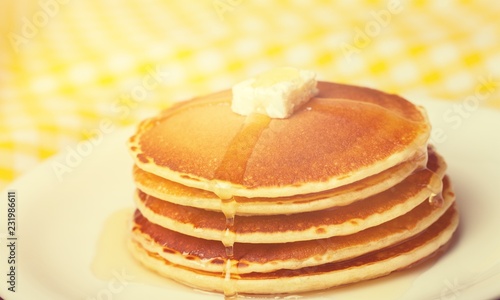 Stack of Small pancakes in syrup on background