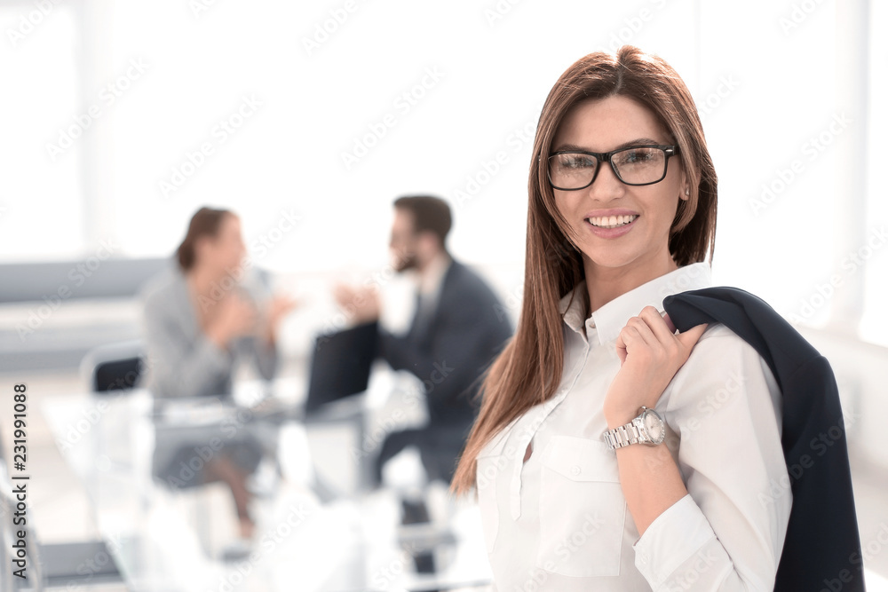 smiling business woman standing with a jacket over her shoulder smiling business woman standing with a jacket over her shoulder