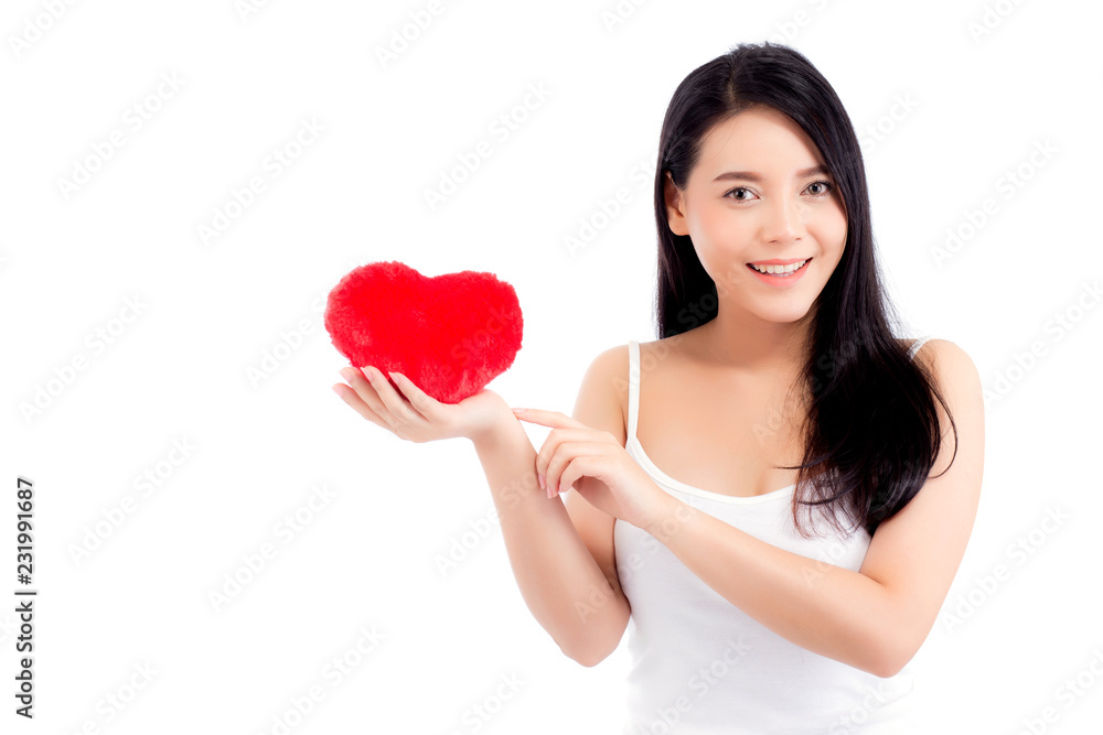 Portrait of beautiful asian young woman holding and pointing red heart shape pillow and smile isolated on white background, valentines day, holiday concept. Portrait of beautiful asian young woman holding and pointing red heart shape pillow and smile isolated on white background, valentines day, holiday concept.
