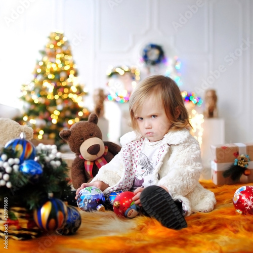 Ребенок ждет чудо в Новый год. С Новым годом! Счастливого Рождества! Елка с новогодними игрушками. Девочка с подарками. 