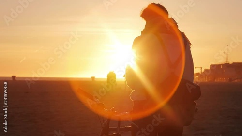 Bikes ride past girl taking in beautiful sunset at beach