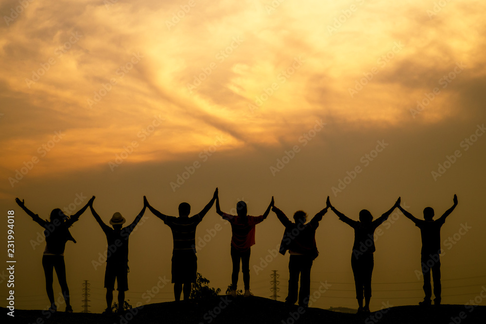 Successful female hiker achievement climbing on top the mountain.Team work concept and helping concept. Silhouette landscape.