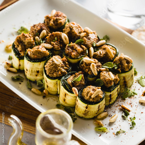 Fotografering vegan appetizer of grilled zucchini and olive pate on a festive table