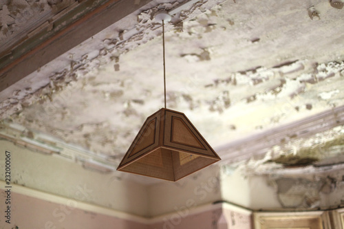 old fashioned light shade on decaying ceiling