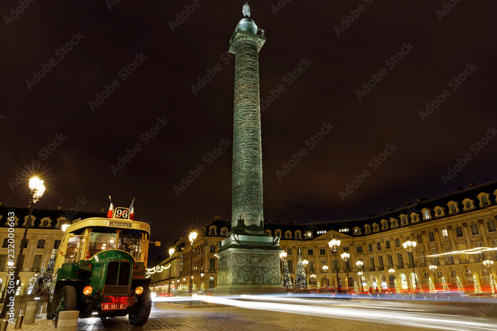 Paris, France - December 17, 2017: Old school bus at Place Vendome in Paris by night