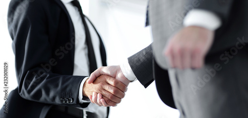 Friendly smiling businessmen handshaking. Business concept photo