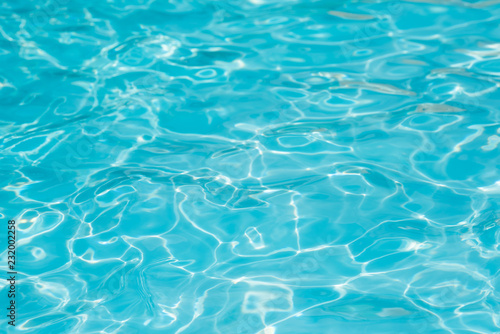 Blue and bright water in swimming pool with sun reflection, Motion of ripple water and gentle wave in pool