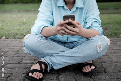 Hand's young hipster woman using smart phone on brick road