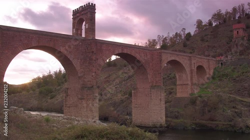 Cinematic tracking shot of Alc√°ntara Bridge at golden hour photo