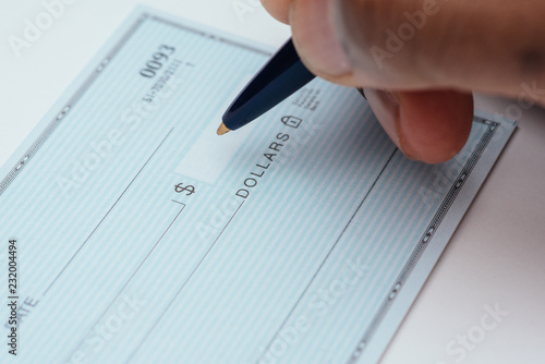 Konstfotografi writing a check with blue pen on white background