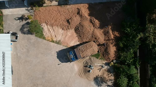 Full HD footage aerial view dump truck unload crushed earth in construction site.