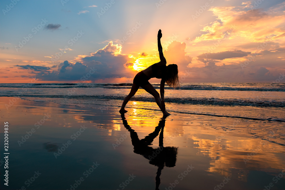 Yoga at sunrise on the beach at St Simons Island, GA Stock Photo