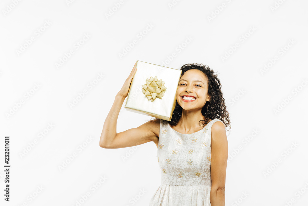 Happy portrait of an excited smiling young brunette holding a golden gift on her shoulder Happy portrait of an excited smiling young brunette holding a golden gift on her shoulder
