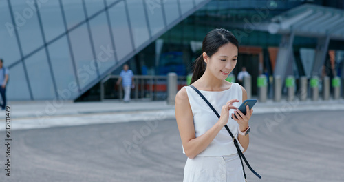 Woman look at mobile phone in Hong Kong city