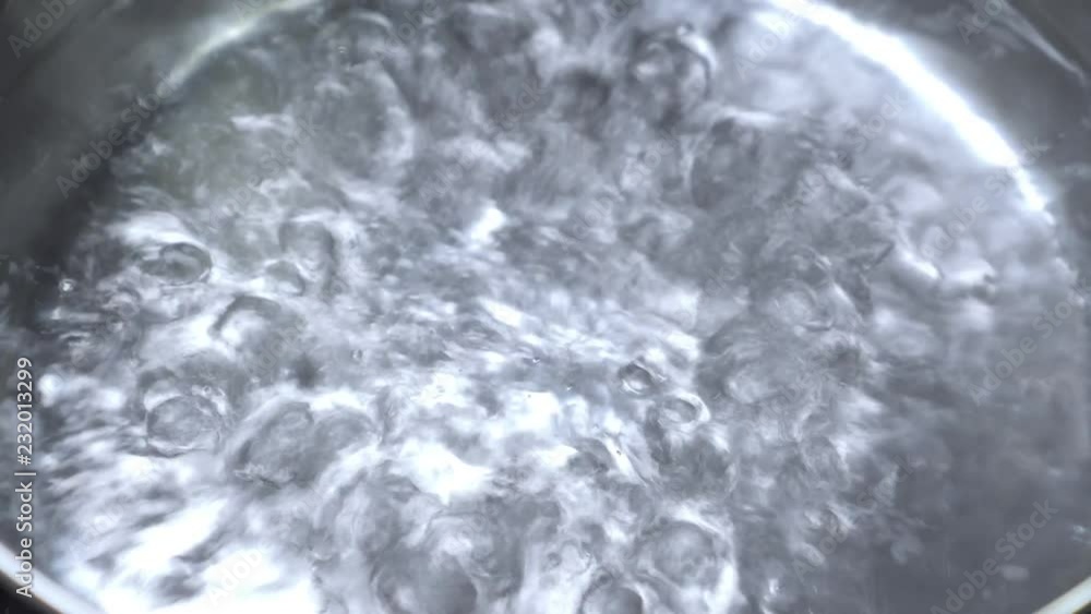 Boiling water in metal pan, closeup Boiling water in metal pan, closeup