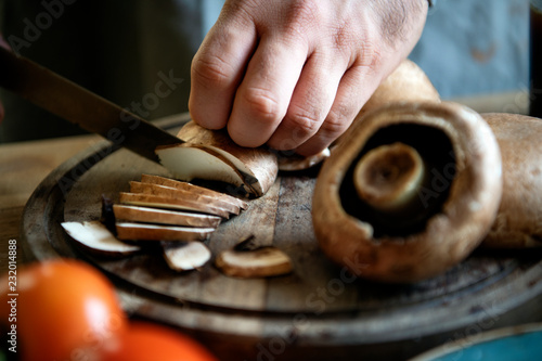 Man slicing portobello mushrooms photo