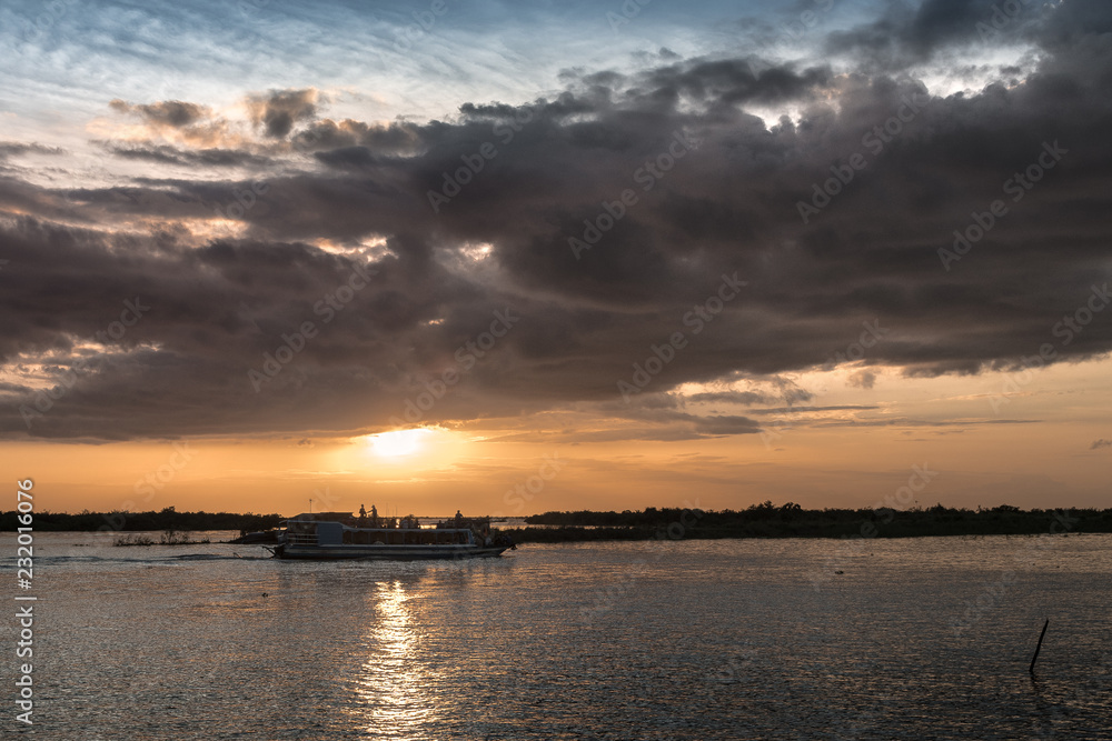 magical sunset on the lake with backlight boat