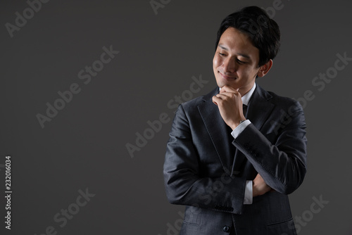 手を顎に当てるビジネスマン © aijiro