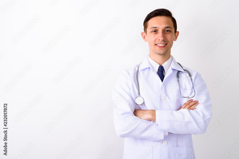 Studio shot of young happy man doctor smiling with arms crossed Studio shot of young happy man doctor smiling with arms crossed