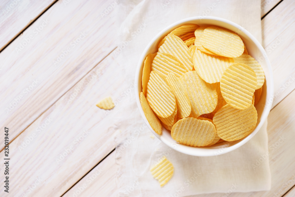 crispy potato chips in a white bowl crispy potato chips in a white bowl