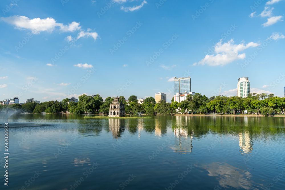 Hoan Kiem lake or Sword lake, Ho Guom in Hanoi, Vietnam with Turtle Tower, on clear day with blue sky and white clouds