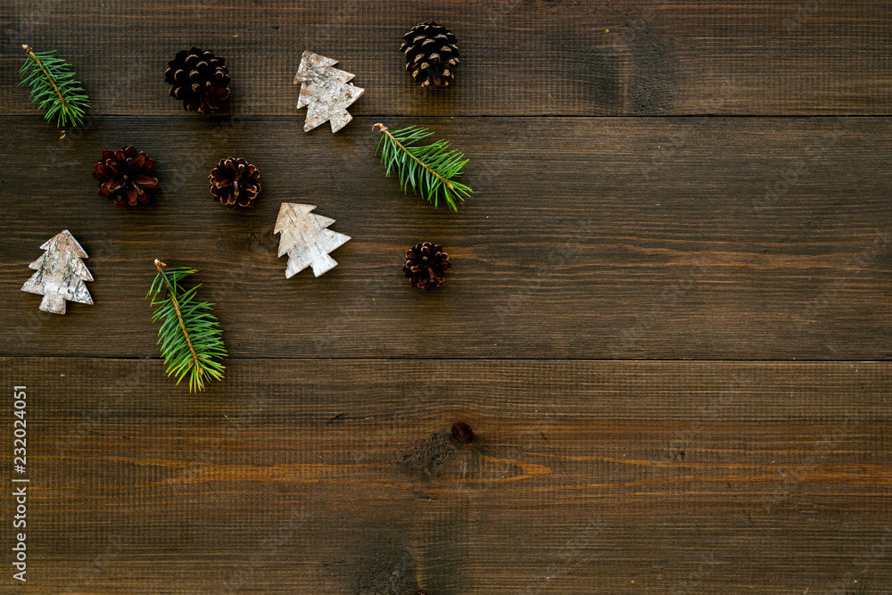 Winter ornament, New Year pattern. Pine sprigs, cones, spruce figure, fir oil on dark wooden background top view space for text Winter ornament, New Year pattern. Pine sprigs, cones, spruce figure, fir oil on dark wooden background top view space for text