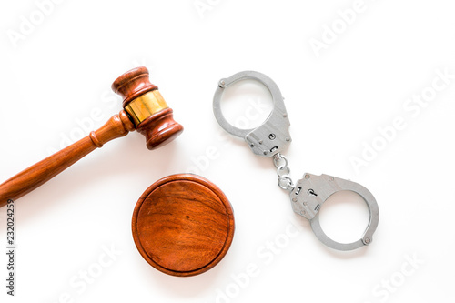 Arrest concept. Metal handcuffs near judge gavel on white background top view copy space