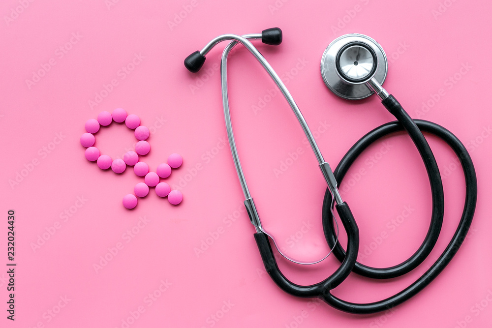 Female diseases concept. Stethoscope near female sign on pink background top view Female diseases concept. Stethoscope near female sign on pink background top view