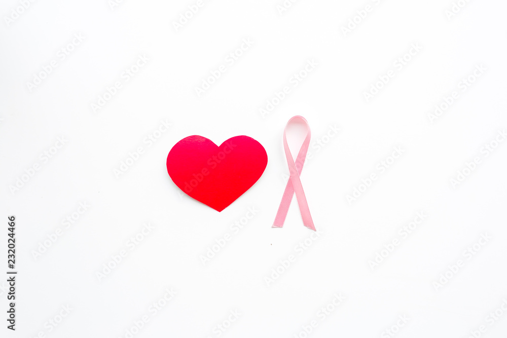 Breast cancer. Mammalogy concept. Symbolic pink ribbon near heart sign on white background top view space for text