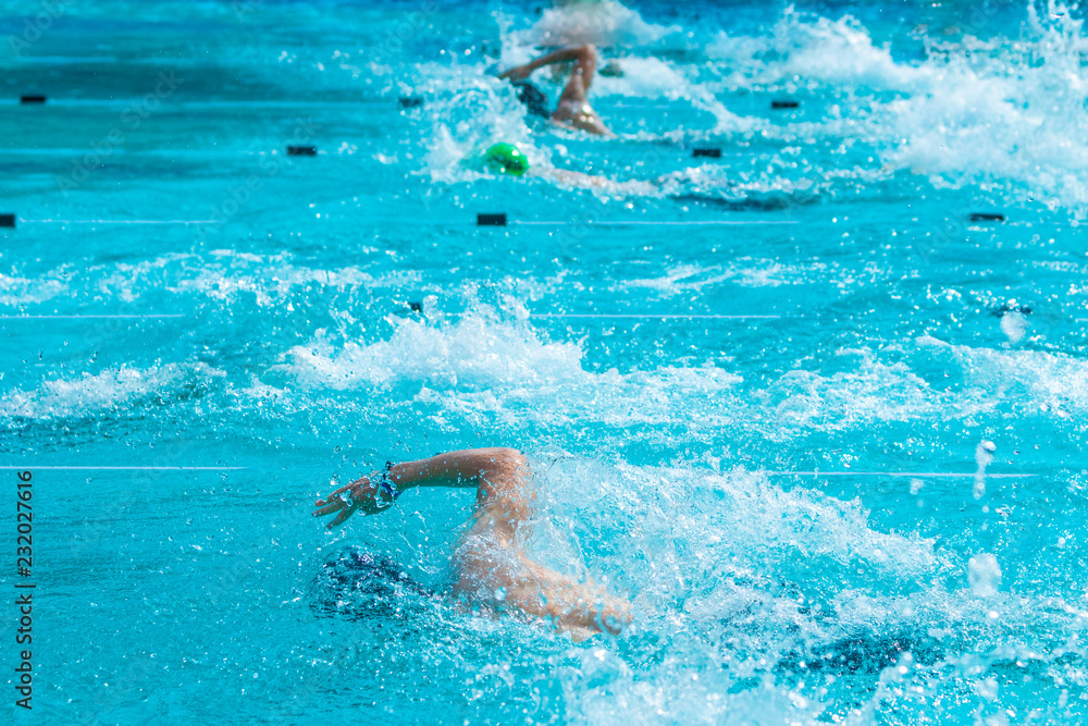 Male swimmers working on their freestyle swimming at a local pool