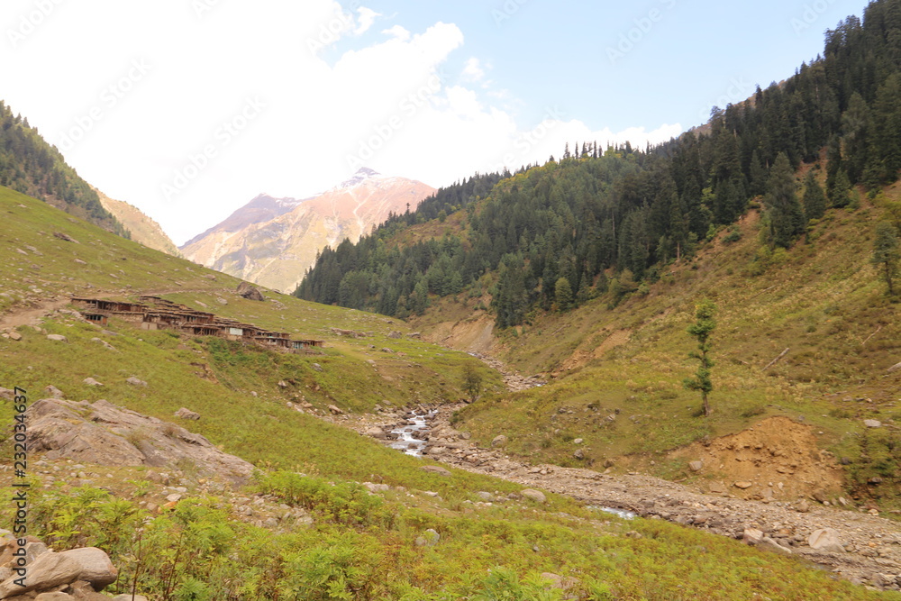 Small lake passing through the mountains under blue sky Small lake passing through the mountains under blue sky