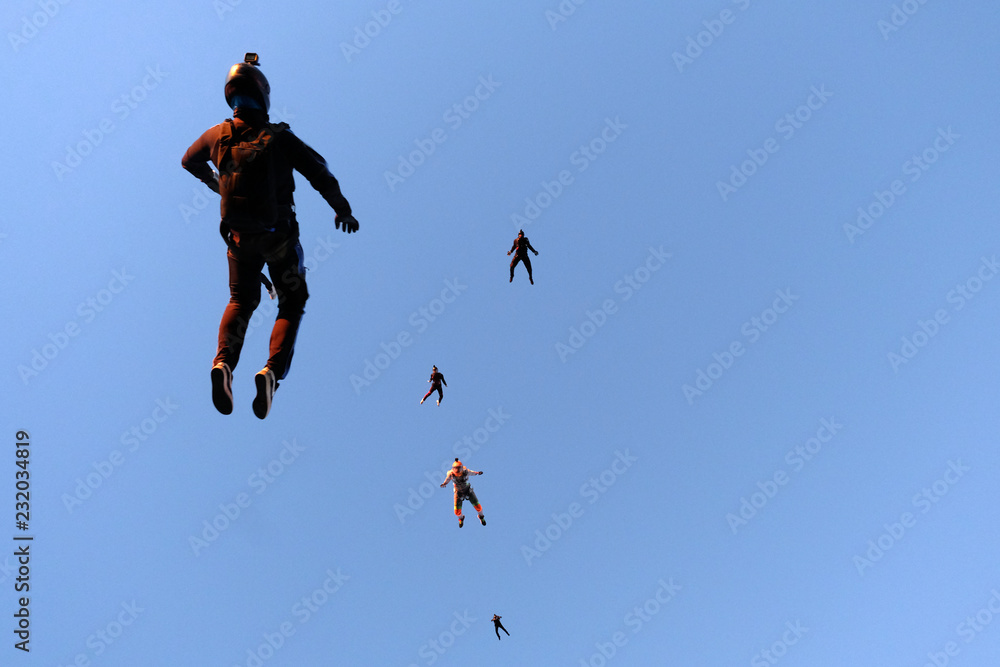 A flock of skydivers is in the sky.