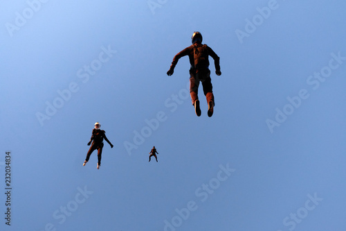 A flock of skydivers is in the sky.