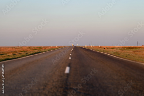 An empty asphalt road in the steppe at sunset. The Astrakhan region. Russia. Tilt-shift effect.