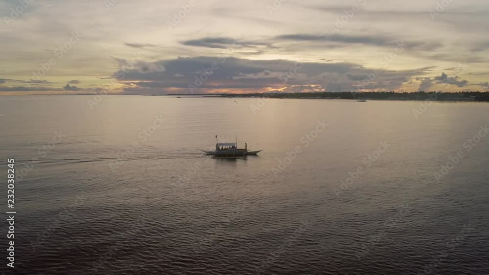 Aerial view of single filipino fishing boat sailing near Lapu-Lapu city at the sunset, Philippines. Aerial view of single filipino fishing boat sailing near Lapu-Lapu city at the sunset, Philippines.