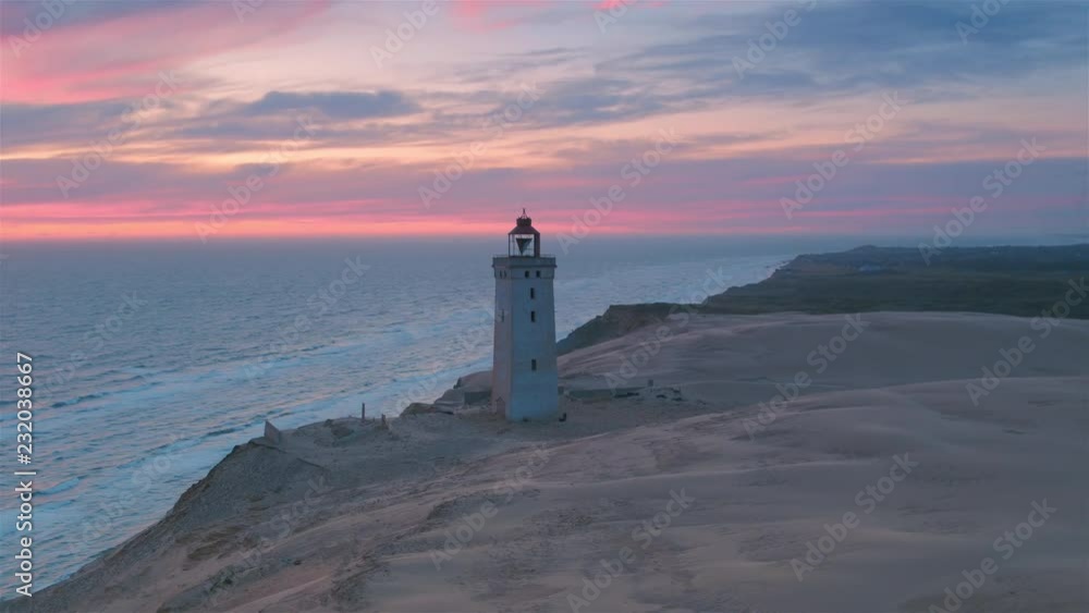 Stunning aerial wide shot of Rubjerg Knude lighthouse at sunset