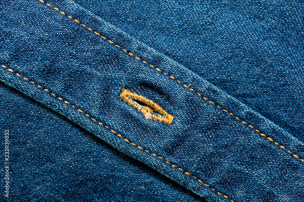 Fototapeta premium Textured blue denim texture stitched with a button-up texture