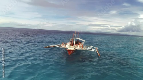 LAPU, PHILIPPINES - MAY 25 2018: Aerial view of single filipino fishing boat sailing near Lapu-Lapu city, Philippines. photo