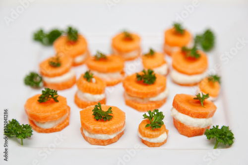 Raw Organic Food. Small Carrot Sandwich Bites With Creamy Vegan Stuffing And Parsley On Top. Close-up, served food, isolated on white background.