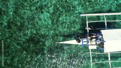 Aerial view of two people preparing to snorkeling in turquoise water in Panagsama Beach, Philippines. photo