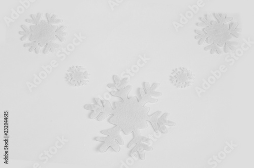 White felt snowflakes on a white background.