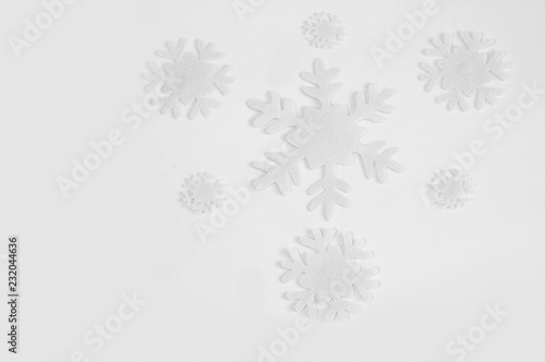 White felt snowflakes on a white background.