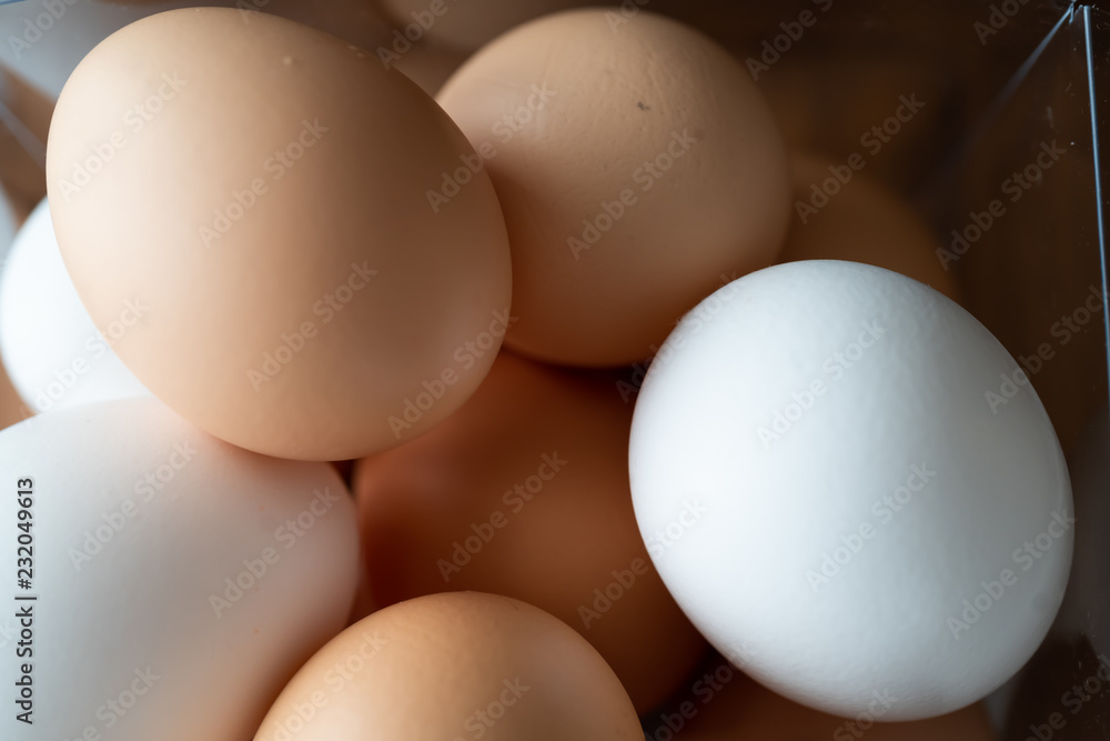 Brown and white eggs in plastic transparent cube