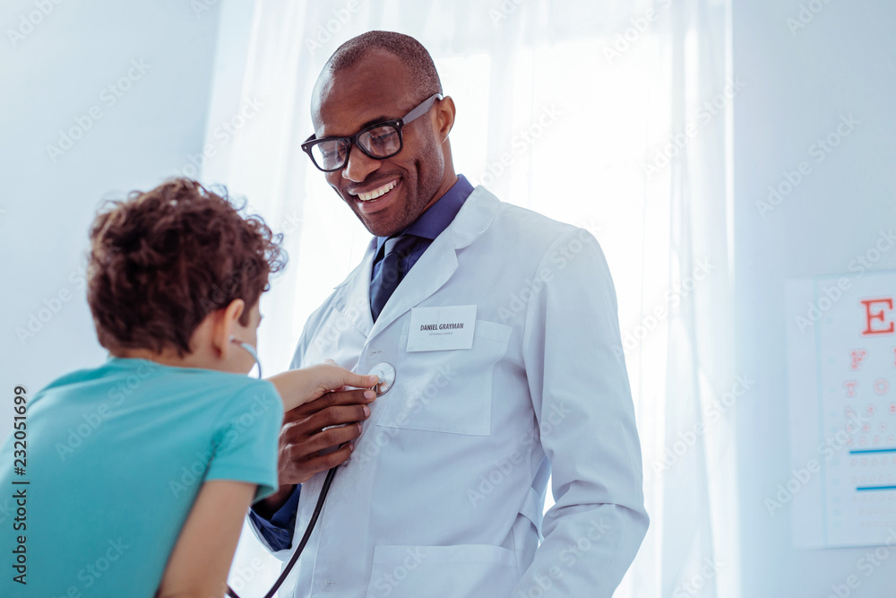 Fototapeta premium Joyful nice boy using a professional stethoscope