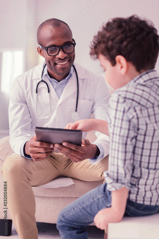 Joyful smart intelligent doctor holding a tablet Joyful smart intelligent doctor holding a tablet