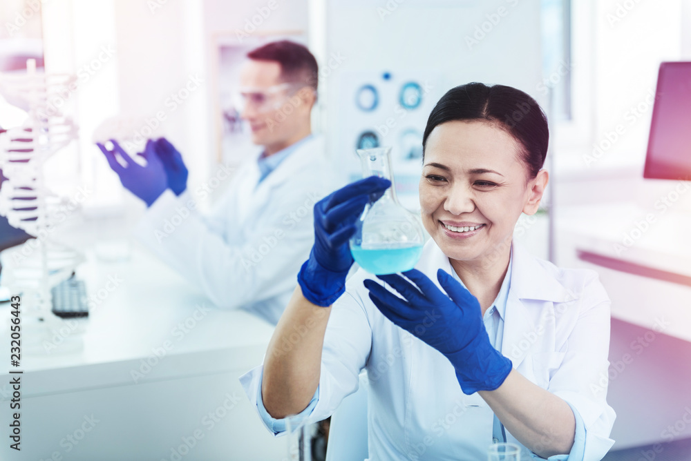 Delighted nice woman looking at the flask Delighted nice woman looking at the flask