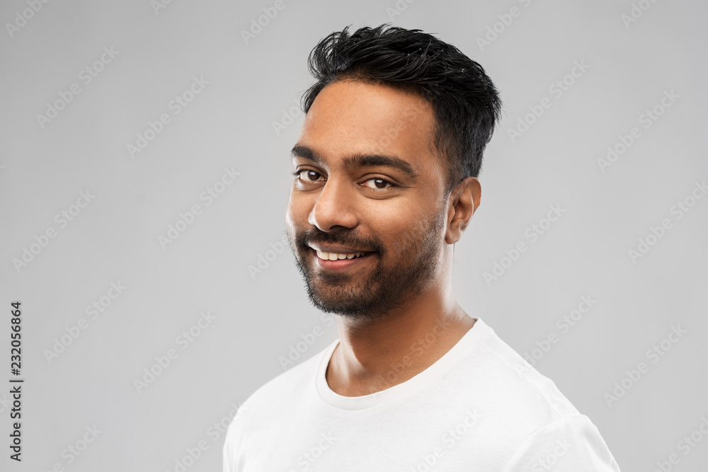 Obraz premium people concept - smiling young indian man over gray background