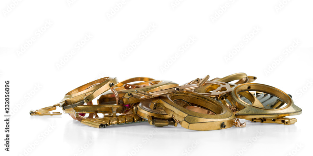 A scrap of gold. Old and broken jewellery, watches of gold and gold-plated isolated on a white background.