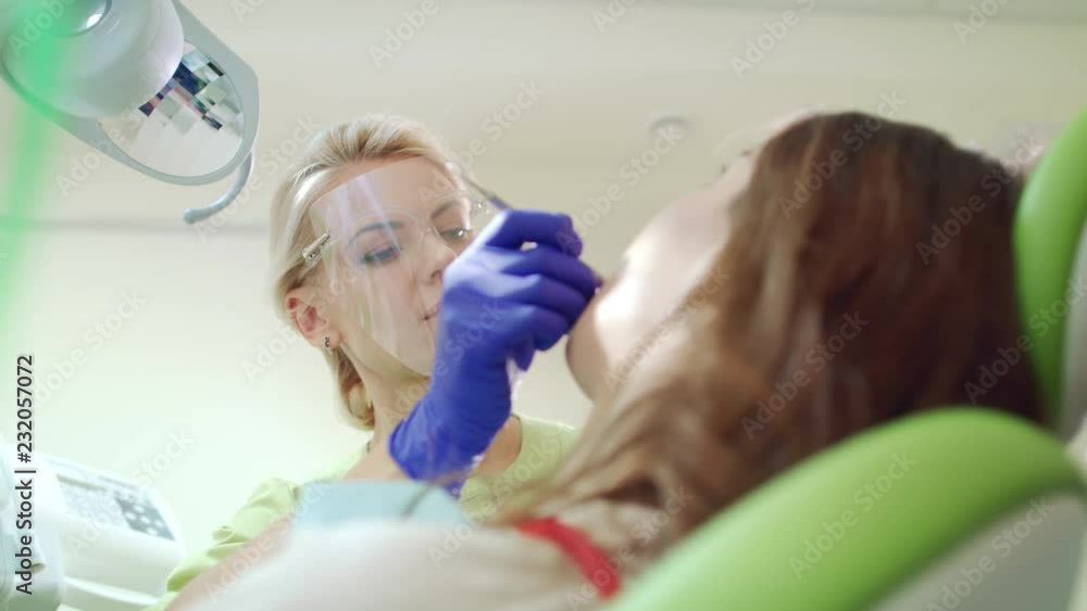 Stomatology specialist working with patient in dentist office. Tooth treatment procedure. Woman doctor treating teeth in dental clinic Stomatology specialist working with patient in dentist office. Tooth treatment procedure. Woman doctor treating teeth in dental clinic